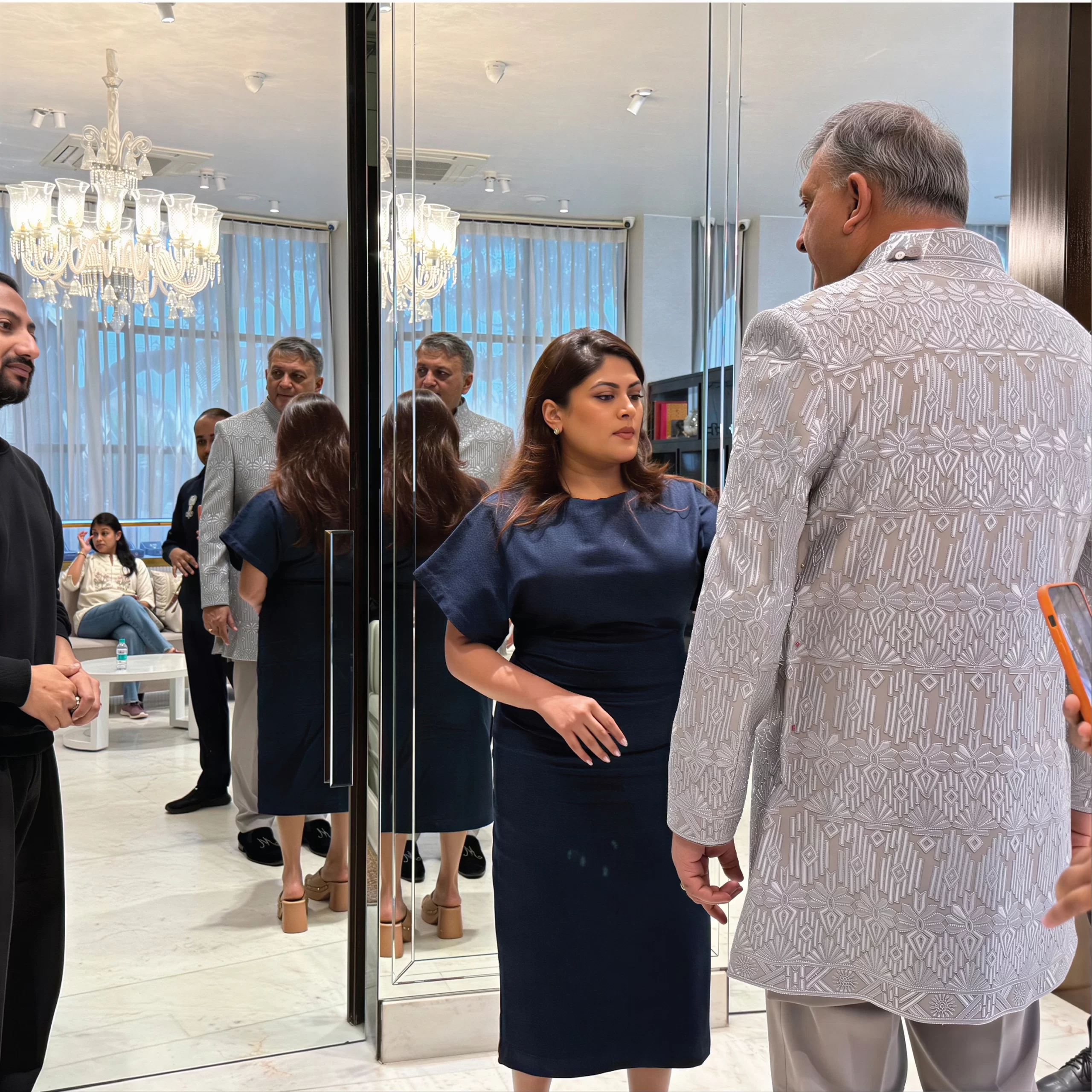 Personal stylist assisting a groom with outfit fitting during a wedding styling session